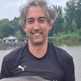 Jeroen Leidelmeijer with a mirror carp at the water