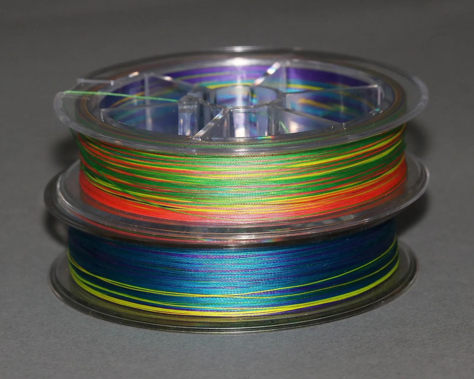 A stack of spools of multicolored braided fishing line