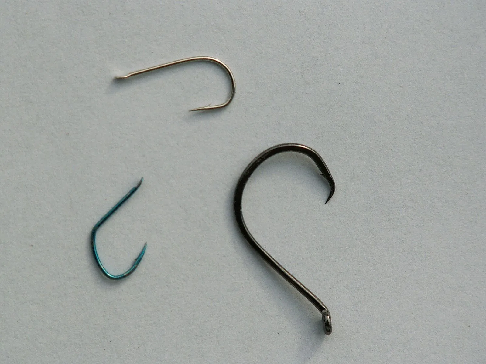 Three fish hooks of different sizes side by side