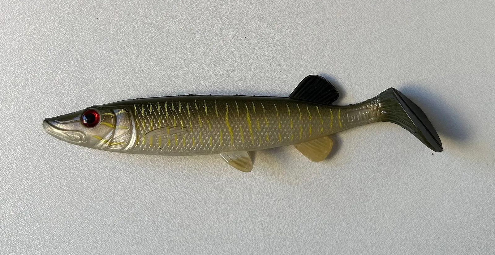 A large soft-plastic swimbait painted like a small pike, with a paddle tail