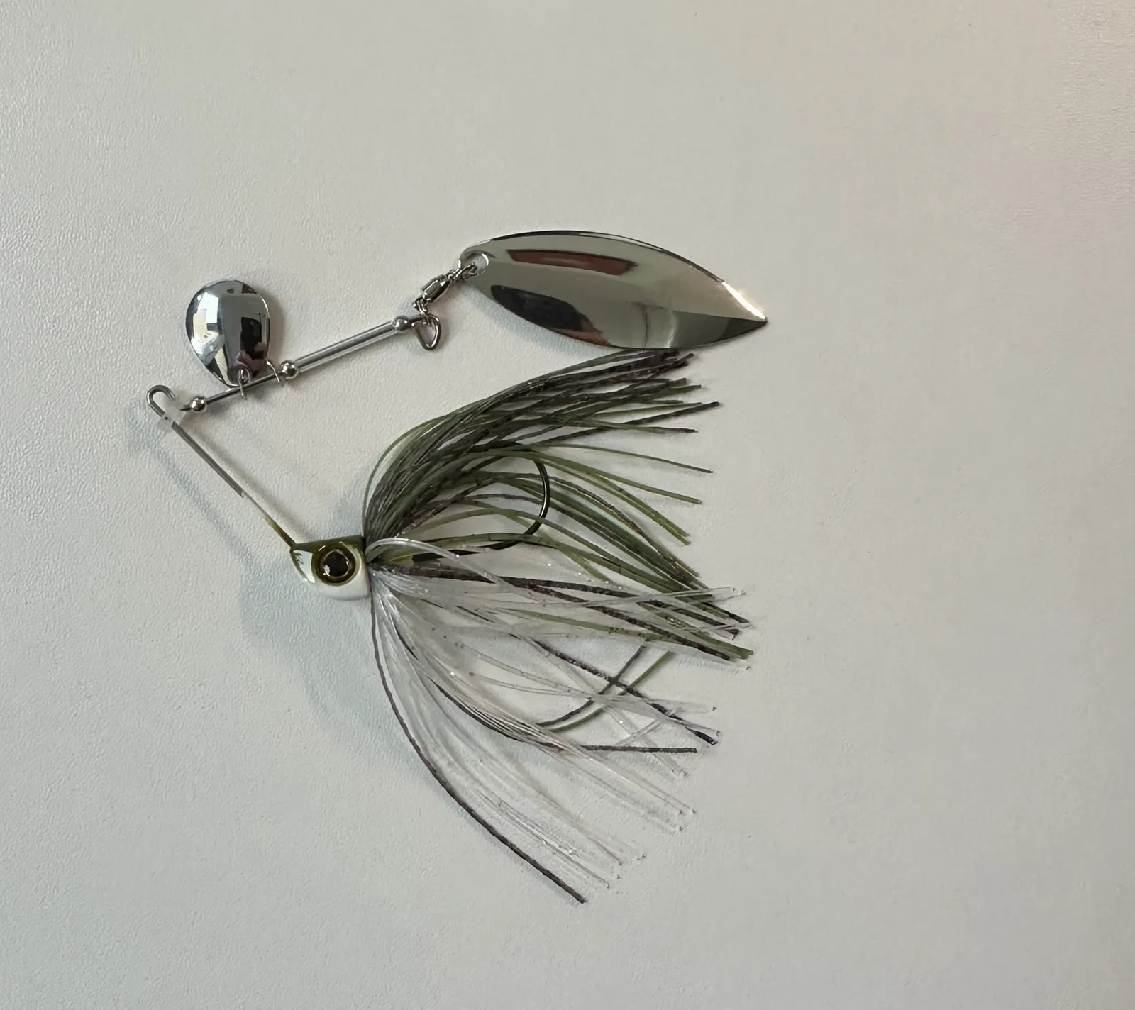 A spinnerbait: bent wire arm with two blades above, a skirted hook below